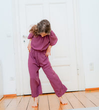 Girls woven jumpsuit sewing pattern with a relaxed silhouette and elastic neckline